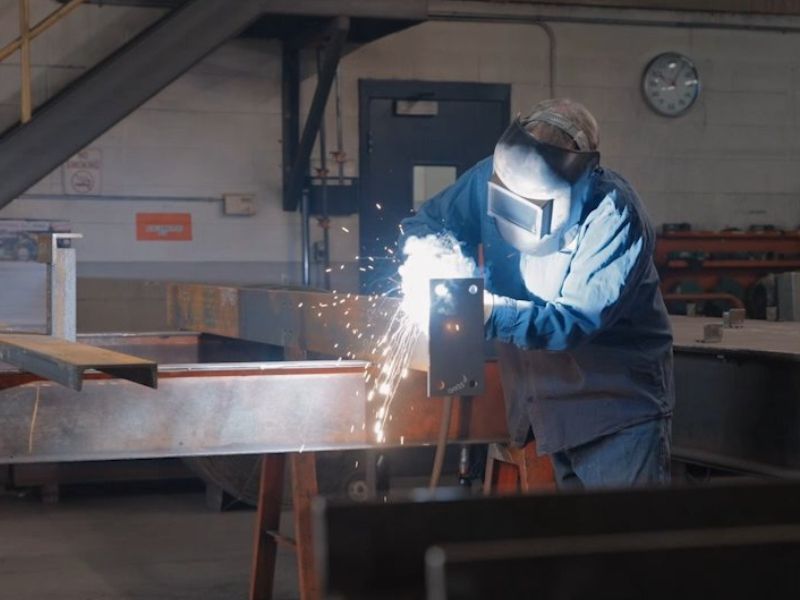 mid-city-steel-about-safety-worker-with-mask-welding-attachment-beam-metal-sparks-800x600