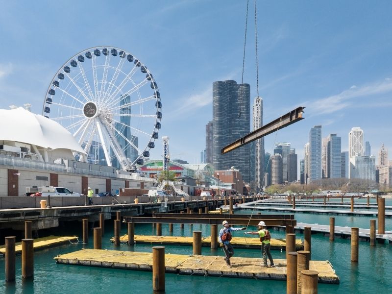 mid-city-steel-fabrication-navy-pier-two-workers-moving-metal-beam-800x600