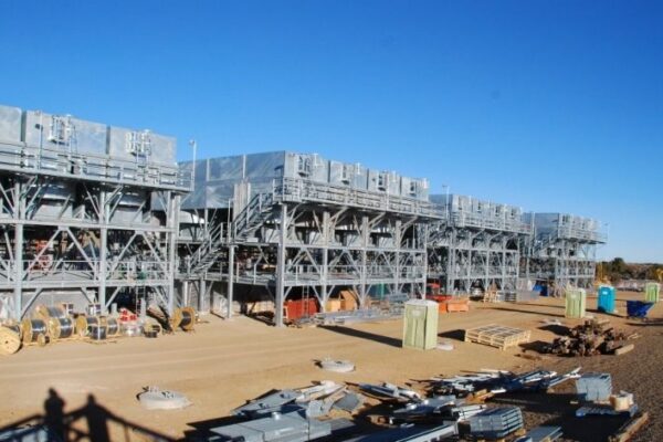 mid-city-steel-cow-canyon-central-processing-facility-industrial-gallery-4 Large industrial cooling units on elevated metal platforms at a construction site under a clear blue sky.