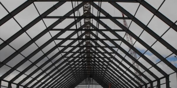 mid-city-steel-drake-cement-industrial-gallery-6 Steel beams form the frame of a building under construction against a cloudy sky.