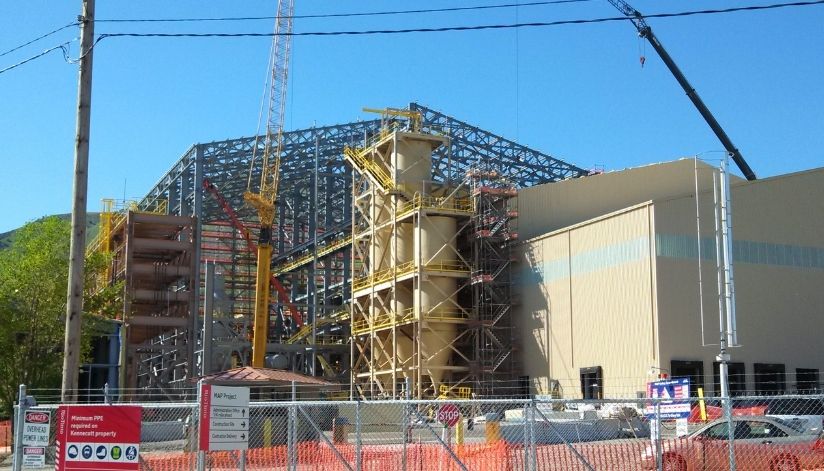 mid-city-steel-kennecott-magna-utah-angle-industrial-project Steel-framed industrial building under construction with cranes, scaffolding, and construction equipment on site.
