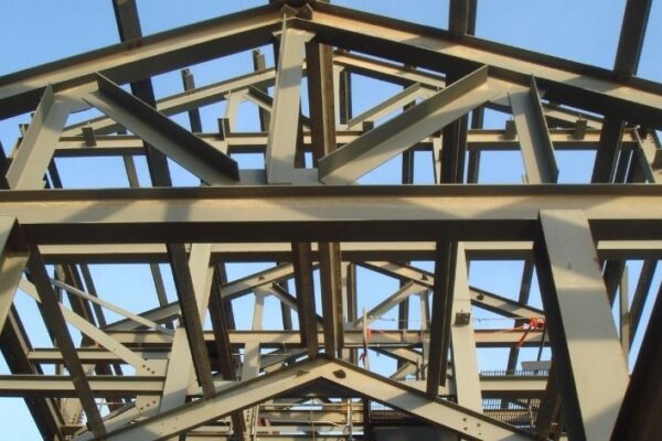 mid-city-steel-pattison-frac-sand-plant-industrial-project-gallery-2 Steel framework of a building under construction against a clear blue sky, viewed from below.