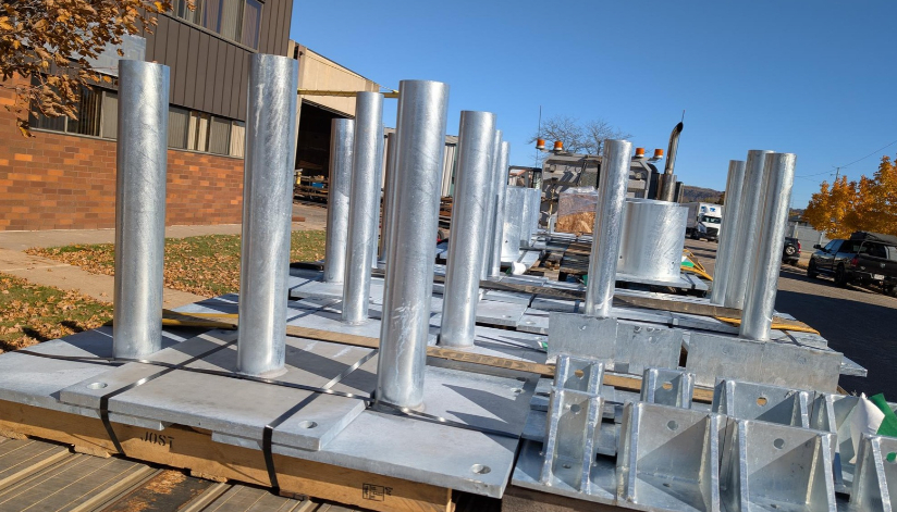 Galvanized steel components and fabricated assemblies stacked on pallets outside Mid-City Steel, ready for transport or installation.